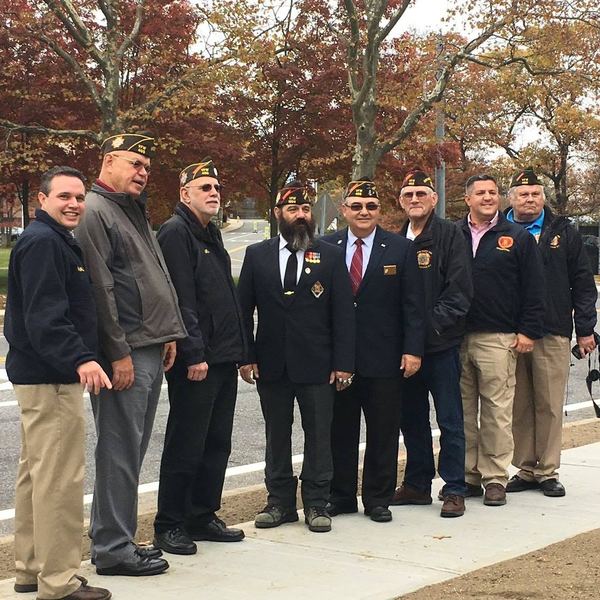 Members in VFW caps and jackets standing on a sidewalk