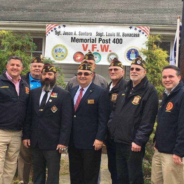 Members in VFW jackets in front of the Post banner
