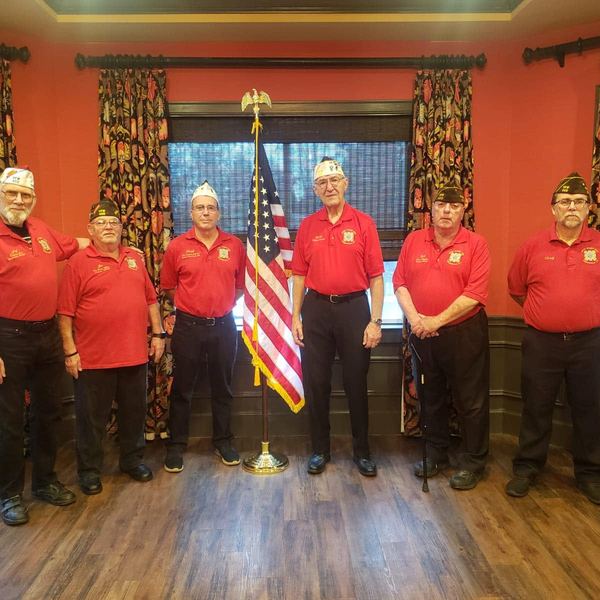 Members in red shirts standing in a hall