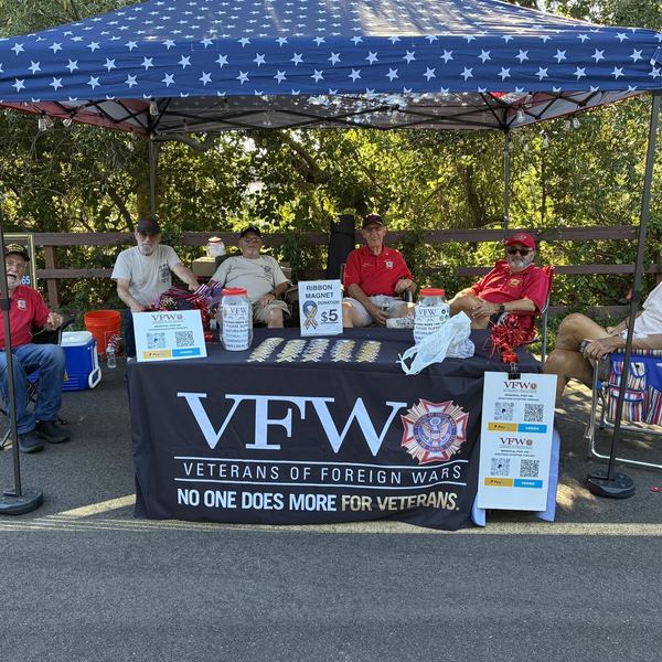 A VFW table under a blue canopy