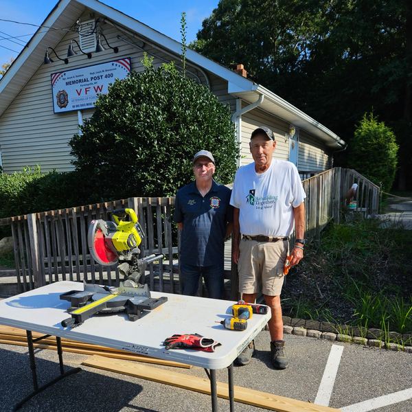 Volunteers with tools beside the repaired ramp at the Post