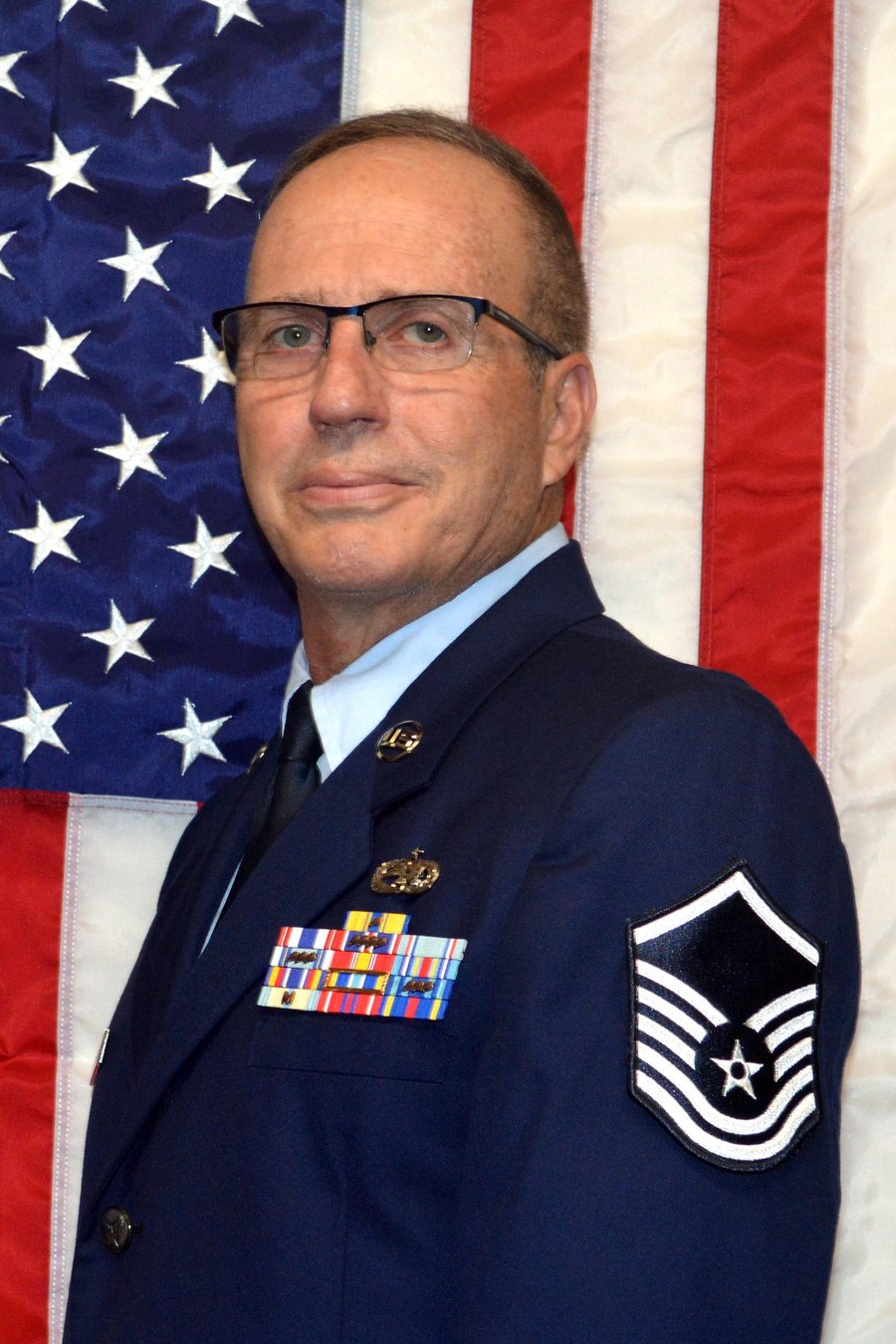 Frank Sanzone in his U.S. Air Force Master Sergeant uniform in front of an American flag